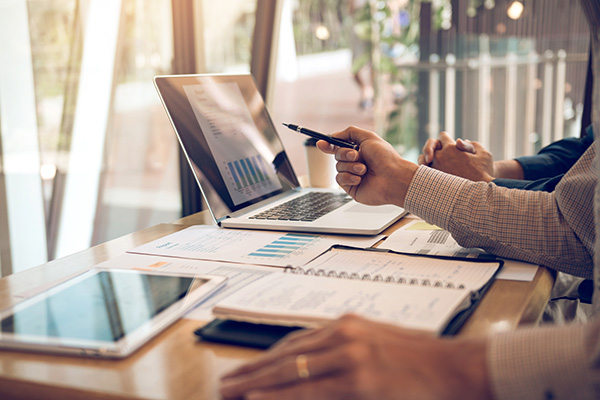 Business partnership pointing to the graph of the company financial statements