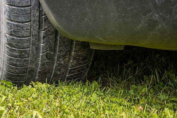 Close-up of the wheel of a car standing on the lawn
