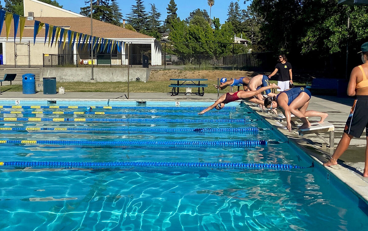Swim team practice at outdoor pool