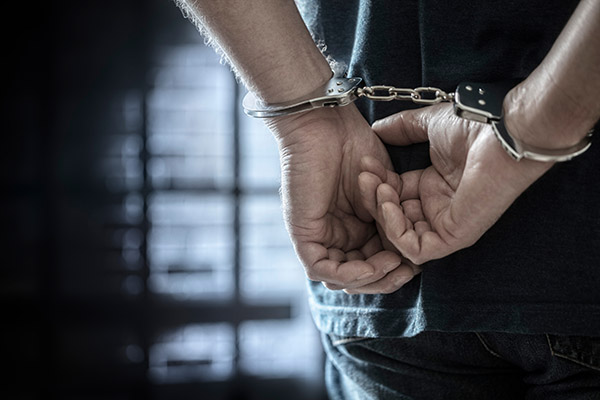 Handcuffed hands behind back in prison.