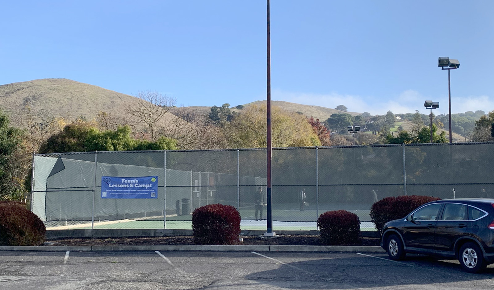The parking lot outside of a tennis court