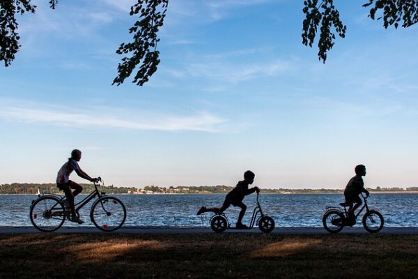 Image of children on scooter and bicycles.