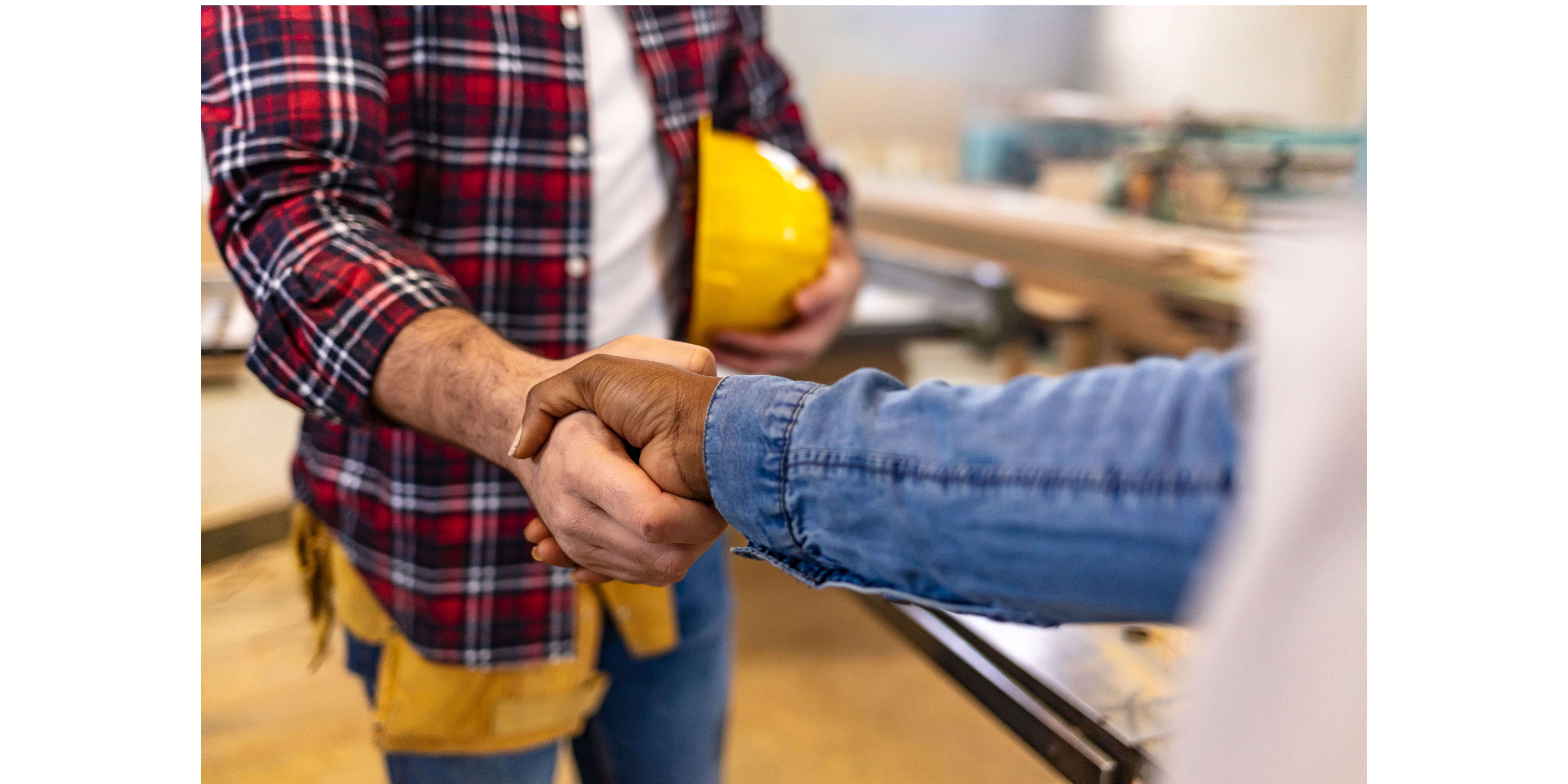 Homeowner shaking the hand of a contractor with a yellow construction hat
