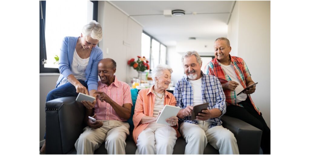 five seniors looking at tablets and smiling