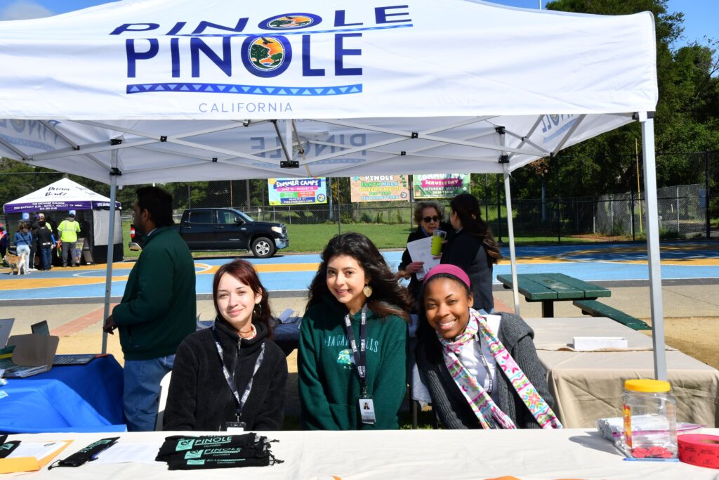 Three Media and Communication Fellows at an outreach booth.