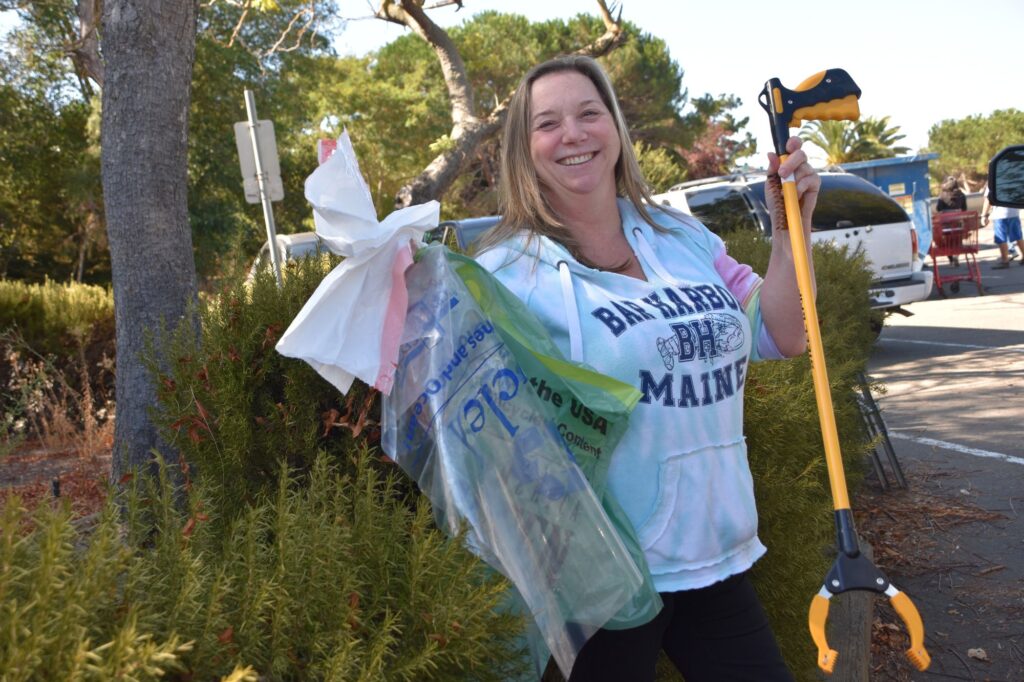 woman smiling with cleanup tools
